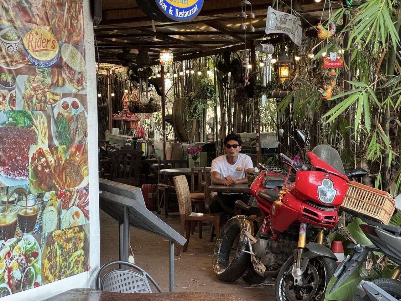 Riders Corner bar and restaurant in Chiang Mai, bikes parked under the bamboo shade