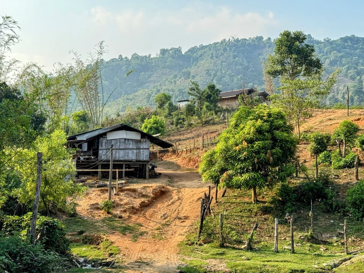 Riding through a Karen village in Mae Hong Son province — multi-day routes pass through communities rarely visited by outsiders